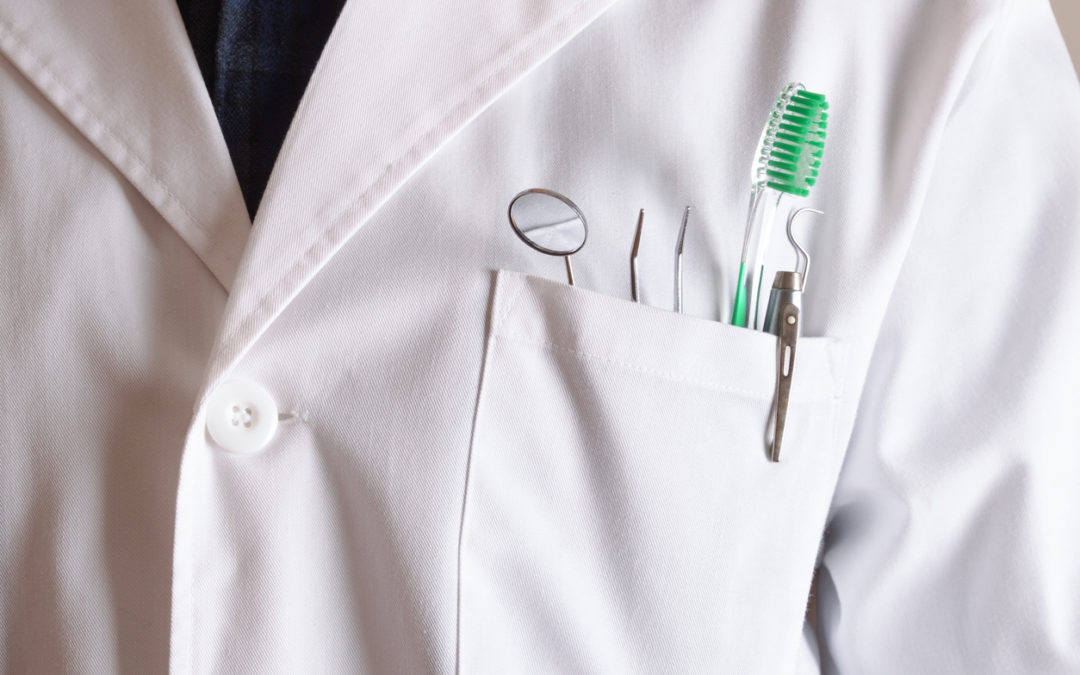 White coat of dentist with tools in his pocket