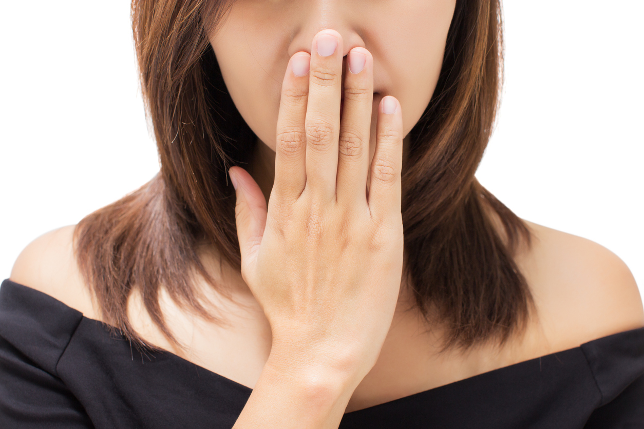 Scared young woman with her hand on her mouth